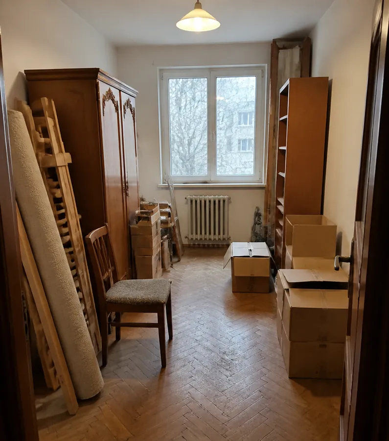 Simulare vizuală: cameră ocupată de mobilier și cutii înainte de debarasare